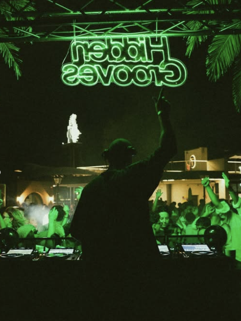 DJ playing beneath a Hidden Grooves sign