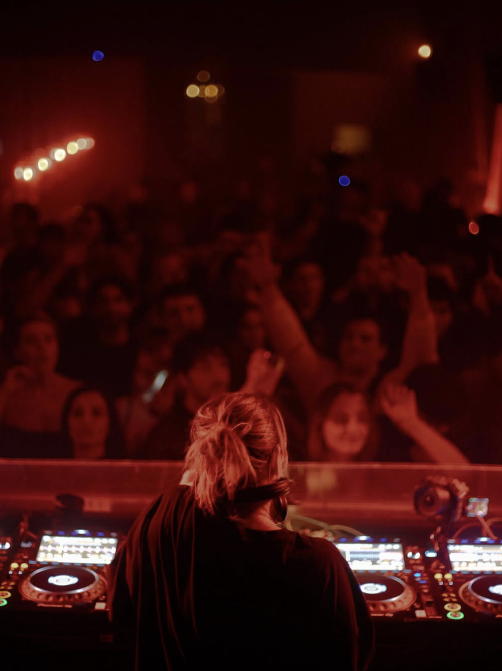 DJ playing to a red-lit crowd
