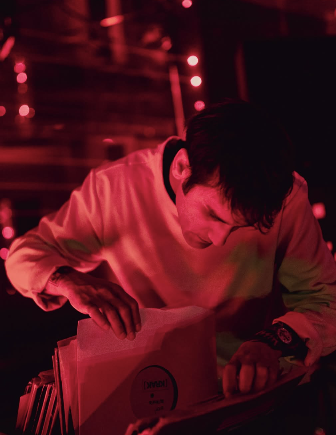 DJ selecting a record under red lights